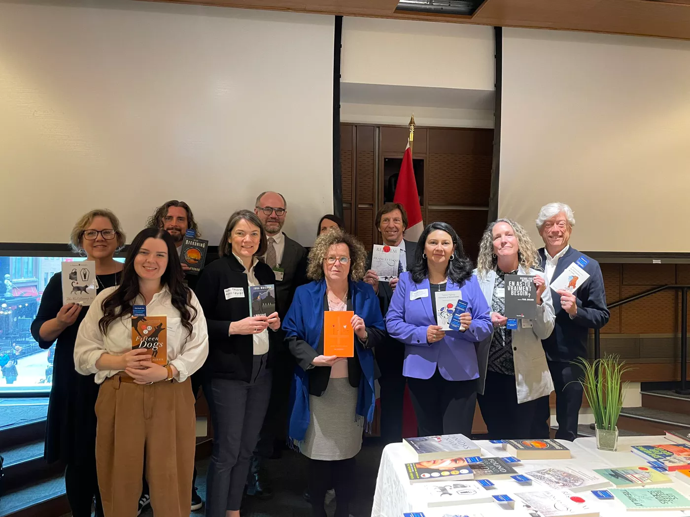 Group of people posing with books in hand